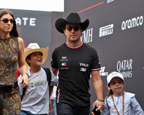 Sergio Pérez wearing a Cadillac F1 shirt and cowboy hat, accompanied by his family at the United States Grand Prix in Austin.