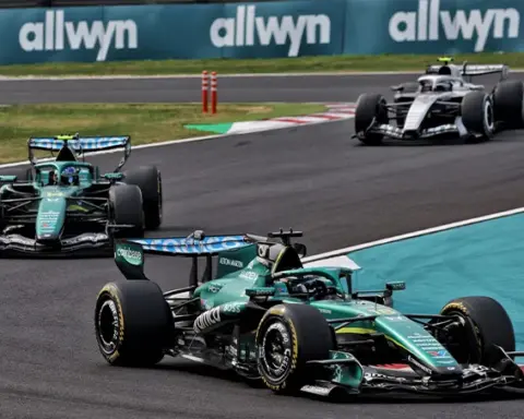 Lance Stroll leads Fernando Alonso in their Aston Martin F1 cars, with Valtteri Bottas following behind during the 2026 Japanese Grand Prix at Suzuka.