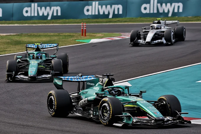 Lance Stroll leads Fernando Alonso in their Aston Martin F1 cars, with Valtteri Bottas following behind during the 2026 Japanese Grand Prix at Suzuka.