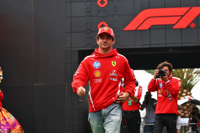 Charles Leclerc walks through the paddock wearing Ferrari team clothing ahead of FP2 at the 2026 Mexico City Grand Prix.